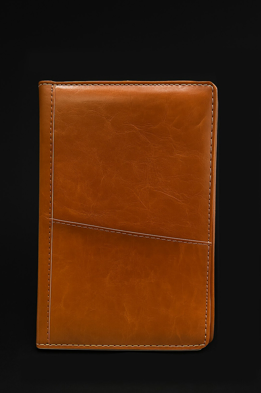 Notebook and pen on a dark wooden desk with warm lamp light